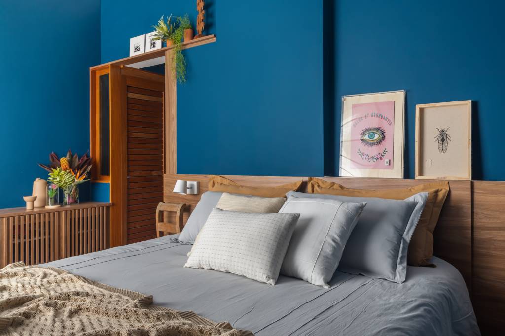 azul-verde-marcam-ape-81m-cozinha-integrada-bancada-espacosa-ketlein-amorim-16-quarto Quarto com parede azul e armário de madeira ripada.