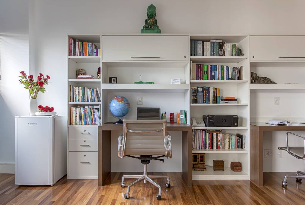 home-office-duplo-criar-espaco-para-duas-pessoas-cristiane-schiavoni-04 Home office com marcenaria branca, bancada de trabalho e estante de livros.