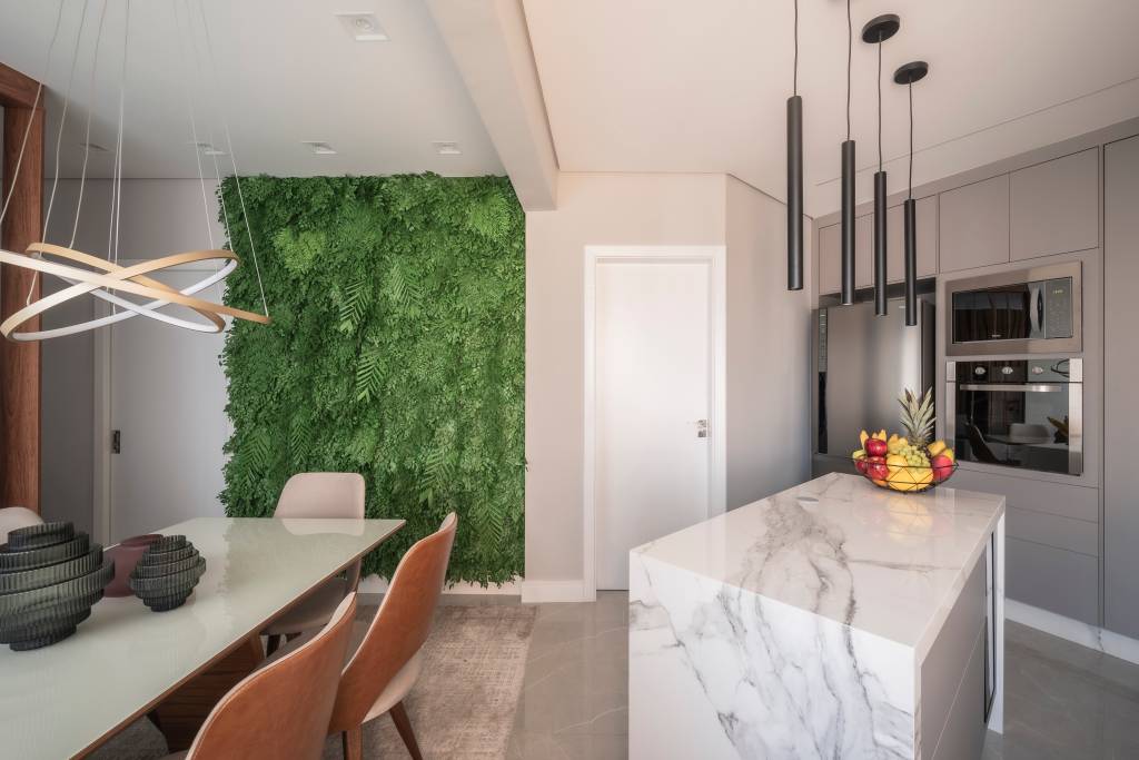 plantas-preservadas-vantagens-e-como-utilizar-pb-arquitetura-02 Sala de jantar integrada com cozinha e jardim vertical com plantas preservadas.