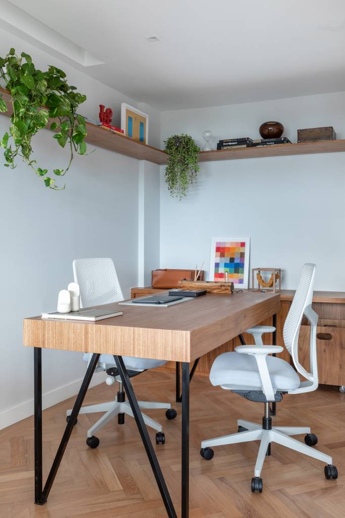 sem-demolicao-ape-280m-pecas-design-sala-intima-bianca-da-hora-12-home-office Home office com mesa de madeira e cadeiras de escritório brancas.