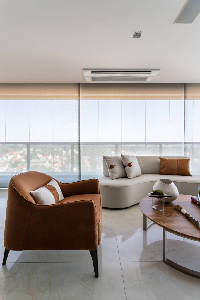 tons-terrosos-decoracao-o-que-transmitem-como-aplicar-projetos-patricia-penna-leandro-moraes-05 Varanda integrada com piso de porcelanato, poltrona em tom terroso e sofá curvo branco.