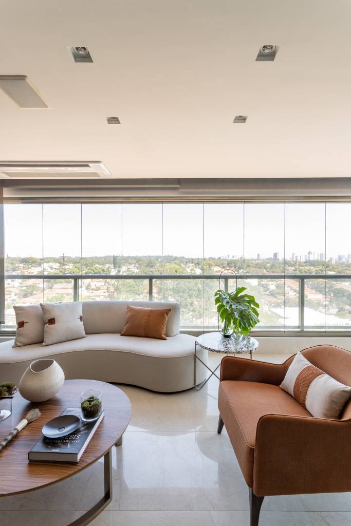 tons-terrosos-decoracao-o-que-transmitem-como-aplicar-projetos-patricia-penna-leandro-moraes-06 Varanda integrada com piso de porcelanato, poltrona em tom terroso e sofá curvo branco.