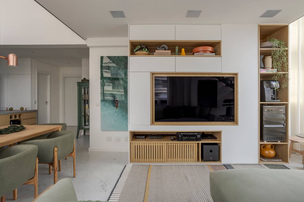 Apê de 110 m² com pé-direito duplo vira duplex com mezanino metálico Apê de 110 m² com pé-direito duplo vira duplex com mezanino metálico. Na foto, marcenaria para a TV da sala esconde um pilar estrutural.