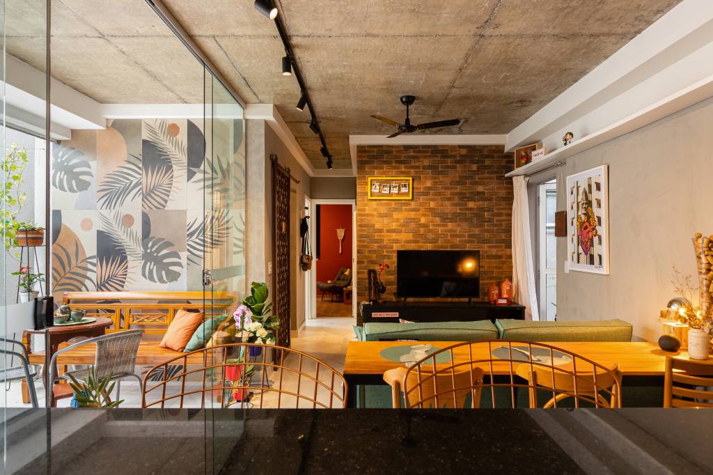 ape-120m-sofa-verde-tijolinho-porcelanato-varanda-spa-grupo-arquitetos-urbanistas-07 Sala de estar com cozinha de bancada preta e sala de estar com sofá verde e parede de tijolinhos de porcelanato.