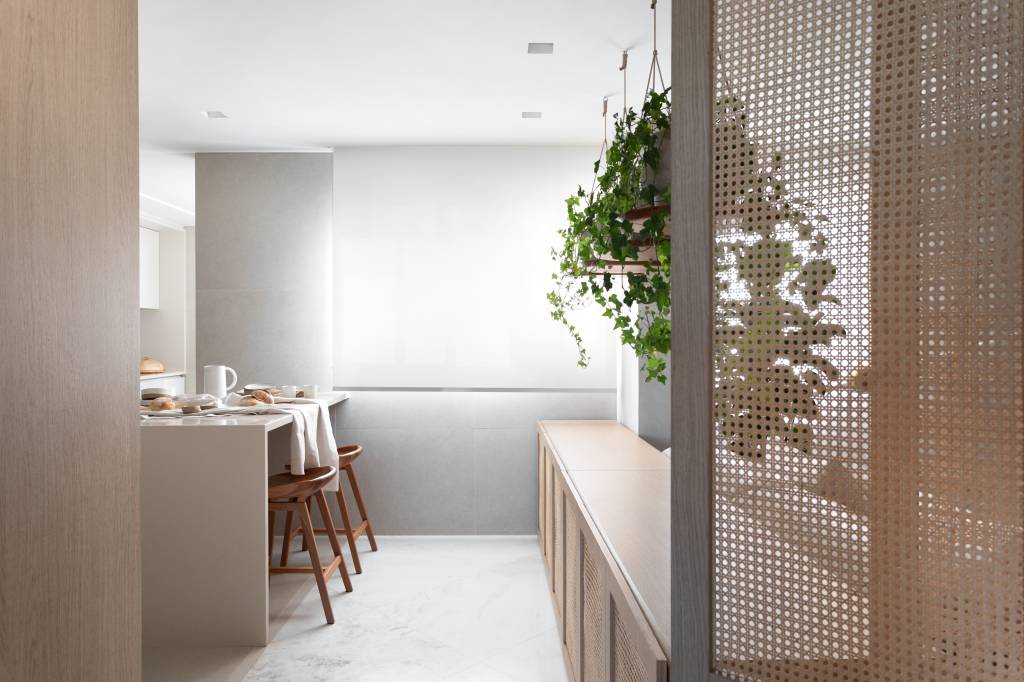 ape-210m-visual-clean-moveis-madeira-plantas-suspensas-archilab-21 Cozinha minimalista com marcenaria branca e mesa embutida com banquetas de madeira.