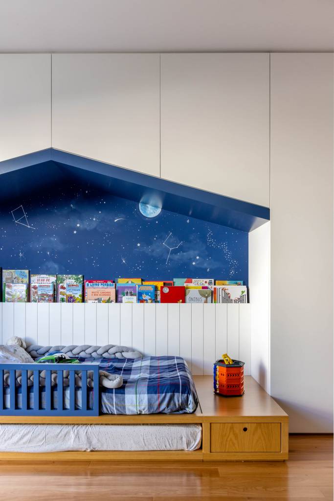 Quarto infantil com nicho em formato de casinha e cama baixa.