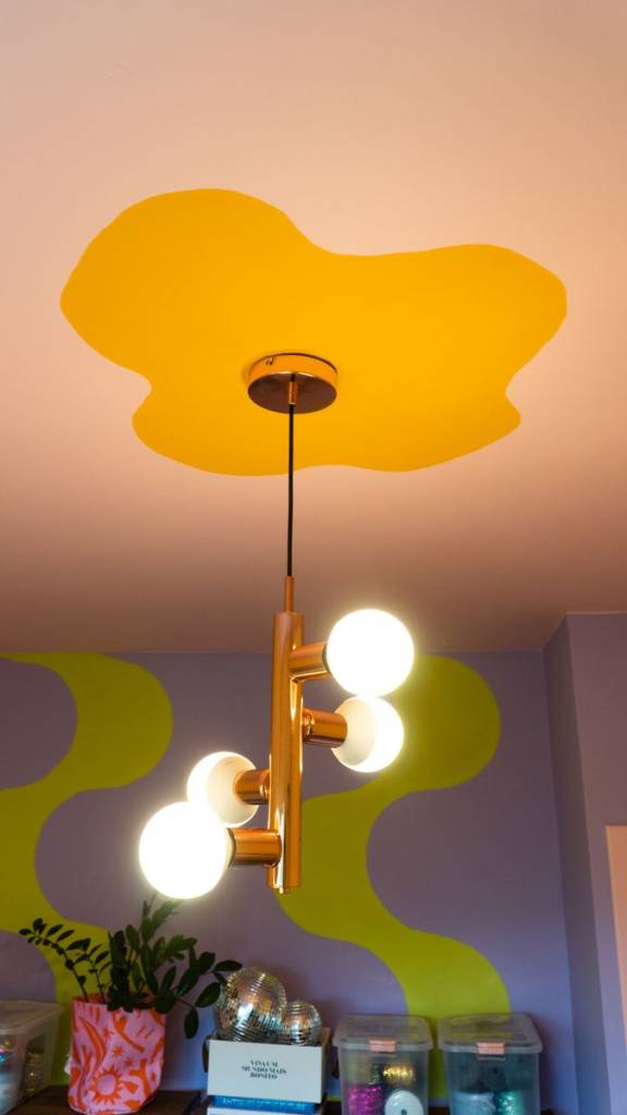 dopamine-decor-descubra-essa-tendencia-suvinil-01 Teto colorido amarelo, rosa claro com luminária esférica e parede verde e roxa