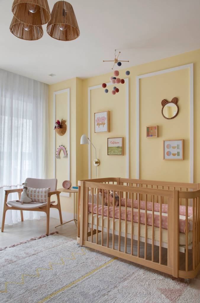 Quarto infantil com parede amarela, boiseries e prateleira com brinquedos.