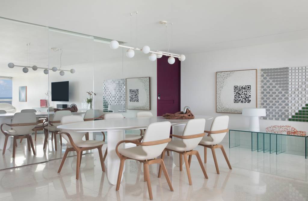 piso-marmore-branco-paineis-espelhados-ape-200m-ana-moura-ana-higino-01-sala-jantar Sala de jantar com piso de mármore, mesa branca, cadeiras estofadas brancas e luminária Ana Neute; parede espelhada ao fundo.