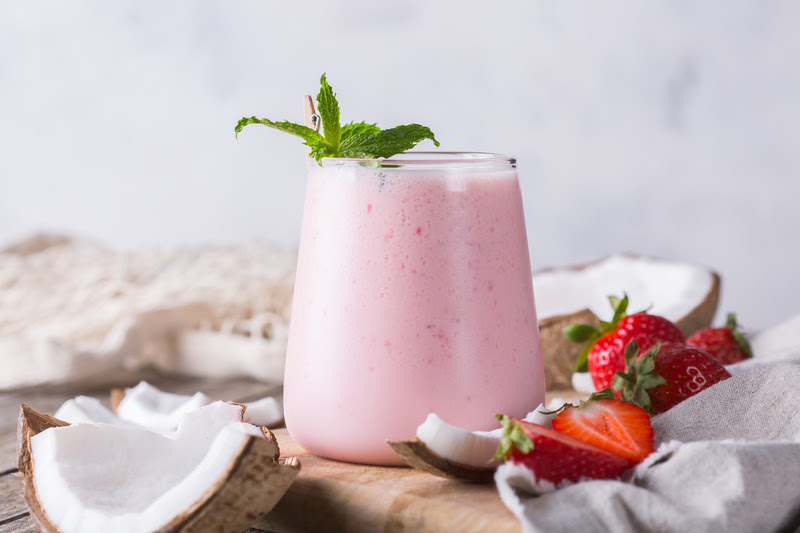 Healthy vegan coconut and strawberry indian lassi Copo com creme de morango e coco.