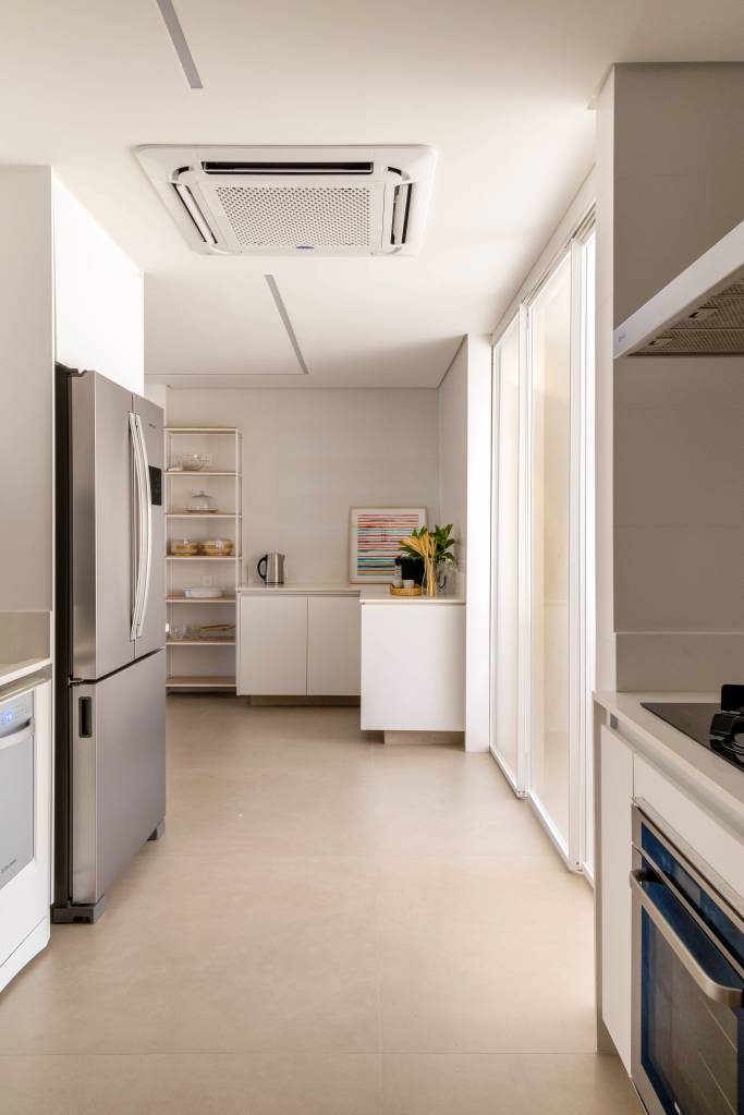 reforma-ape-365m-integra-estar-jantar-cria-copa-330arquitetura-16-cozinha Cozinha com marcenaria branca e piso de porcelanato.