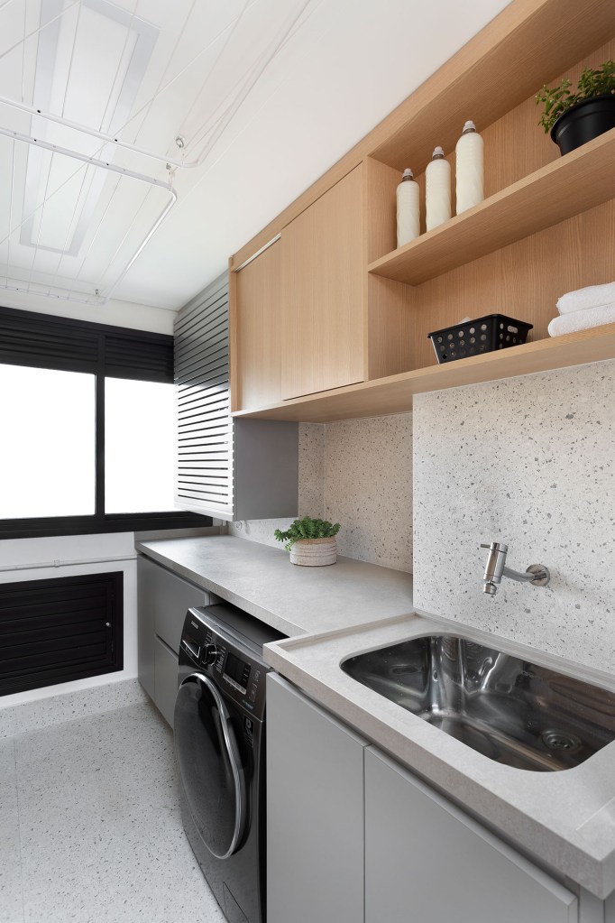 Apê de 142 m² ganha décor neutro que se integra aos eletrodomésticos. Projeto Degradê Arquitetura. Na foto, lavanderia com parede com textura de granilite.