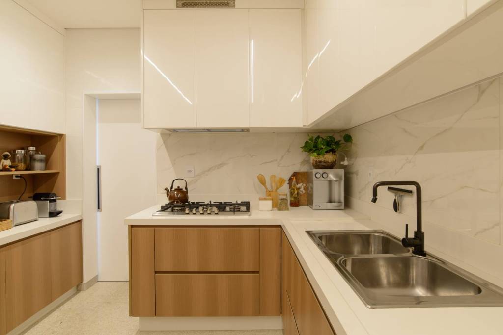 ape-140-m2-feito-para-receber-madeira-marmore-decor-leticia-nannetti-credito-edson-ferreira (6) Apê de 140 m² feito para receber une madeira e mármore no décor. Projeto de Letícia Nannetti. Na foto, cozinha com armarios de madeira e tampo branco.