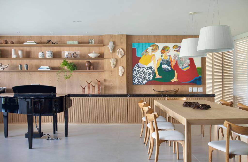 ape-220m-area-gourmet-rede-sala-quarto-varanda-integrada-08 Sala de estar com parede revestida de madeira com persianas, quadro e piano.