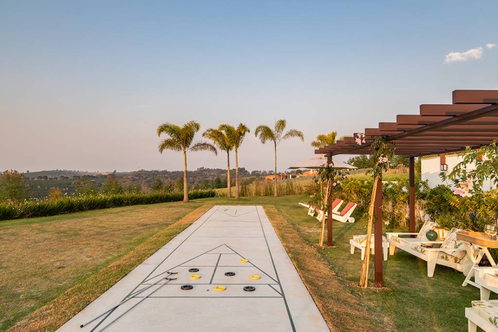 casa-de-campo-terrea-vista-laranjal-espaco-shuffleboard-gilda-meirelles-credito-evelyn-muller (33) Casa de campo térrea tem vista para o laranjal e espaço para shuffleboard. Projeto de Gilda Meirelles. Na foto, varanda com gramado e campo de shuffleboard,