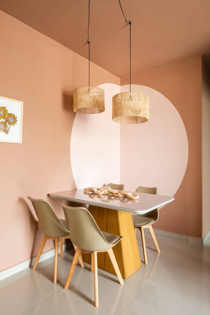 Nathalie Artaxo Fotografia Sala de jantar pequena com mesa retangular e cadeiras taupe; círculo rosa claro na parede e luminária de palhinha.
