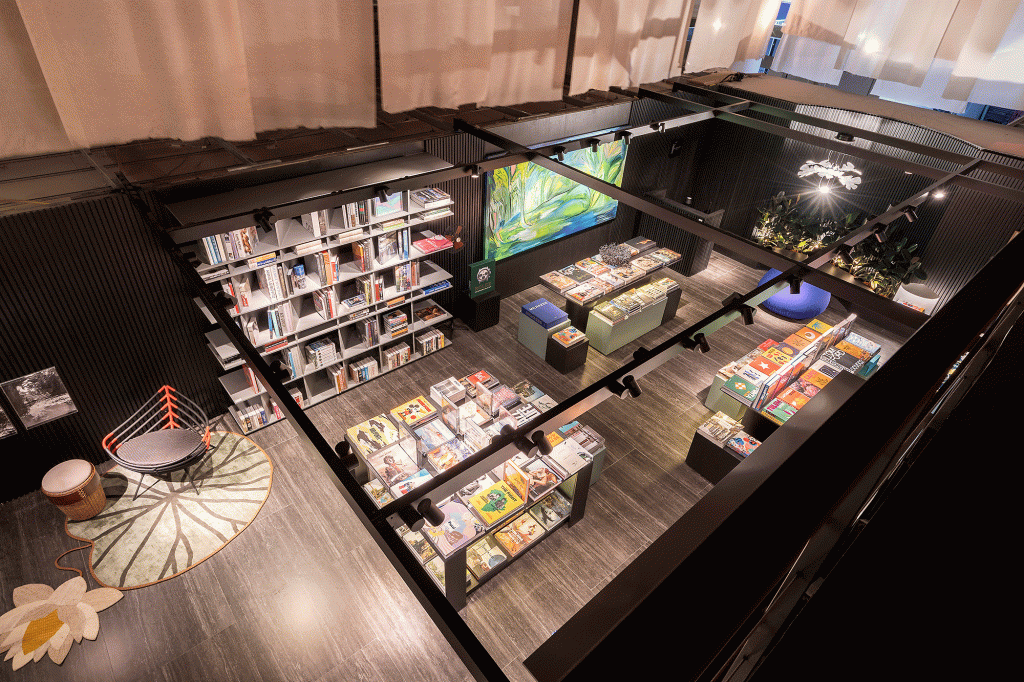 livraria-clima-intimista-repleta-arte-brasileira-nana-cunha-caru-cunha-silvia-camargo-casacor-sp-credito-rafael-renzo (24) Esta livraria tem clima intimista e repleta de arte brasileira. Projeto de Nana Cunha, Caru Cunha e Sílvia Camargo para a CASACOR SP 2023. Na foto, estantes com livros, paredes escuras e quadros.