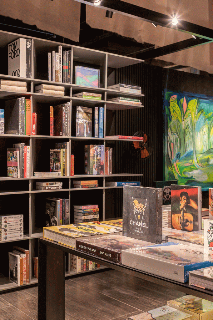 livraria-clima-intimista-repleta-arte-brasileira-nana-cunha-caru-cunha-silvia-camargo-casacor-sp-credito-rafael-renzo (6) Esta livraria tem clima intimista e repleta de arte brasileira. Projeto de Nana Cunha, Caru Cunha e Sílvia Camargo para a CASACOR SP 2023. Na foto, estantes com livros, paredes escuras e quadros.