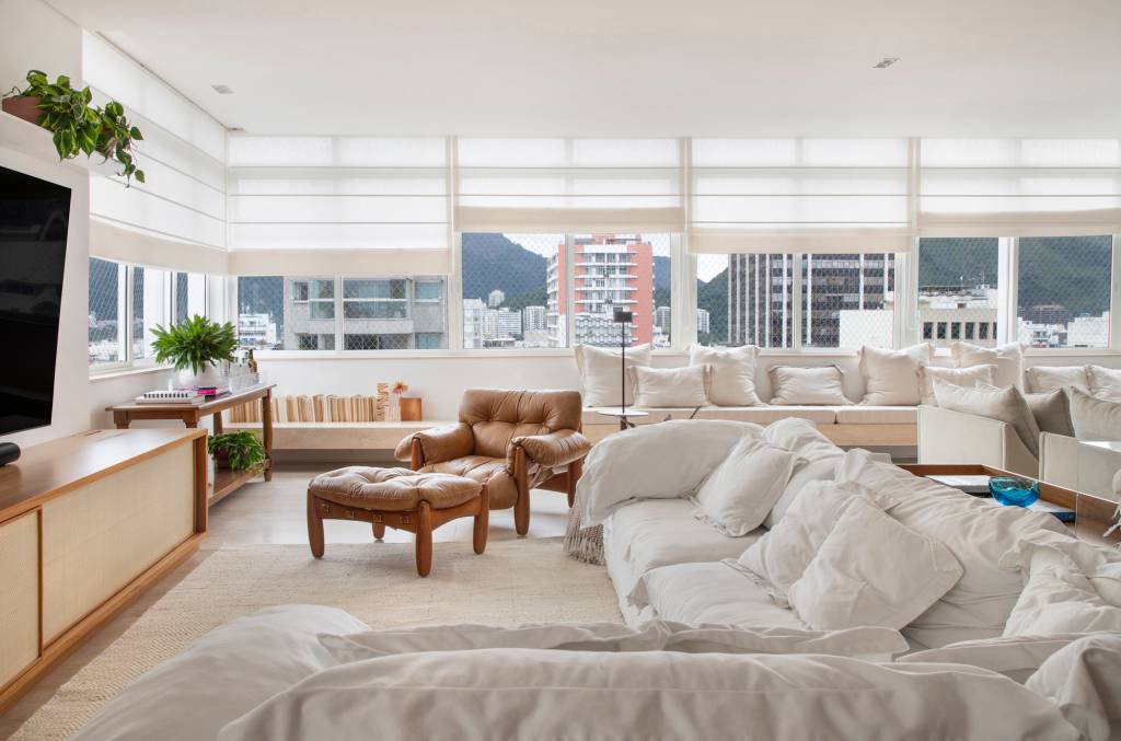 paleta-cores-claras-ripados-madeira-ape-275m-studio021arquitetura-08-sala Sala de estar branca com janelas grandes, sofá branco e poltrona mole.