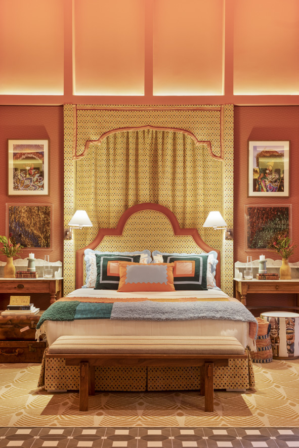 ritmo-alegria-samba-inspiram-casa-paleta-de-cores-vibrante-marcelo-salum-casacor-sp-2023-06 Quarto com cabeceira estampada, cama de casal com roupa de cama colorida e parede coral.
