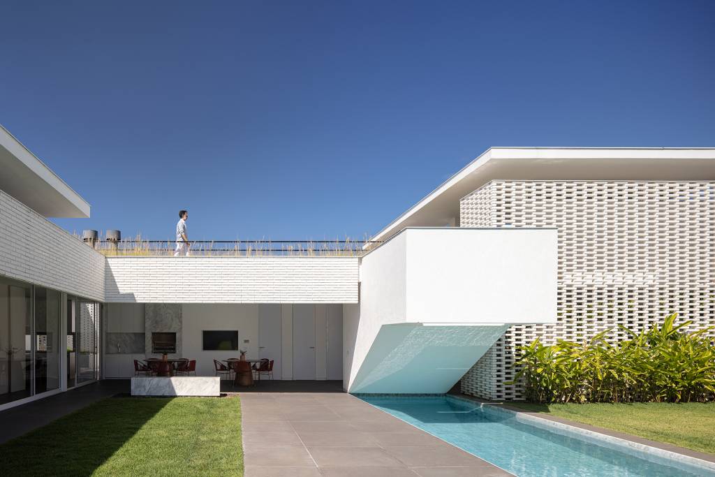tijolos-vazados-brancos-compoem-fachada-casa-600-m2-brasilia-bloco-arquitetos-credito-joana-franca (15) Tijolos vazados brancos compõem a fachada desta casa de 600 m² em Brasília. Projeto de Bloco Arquitetos. Na foto, fachada vazada com blocos vazados, jardim e piscina.