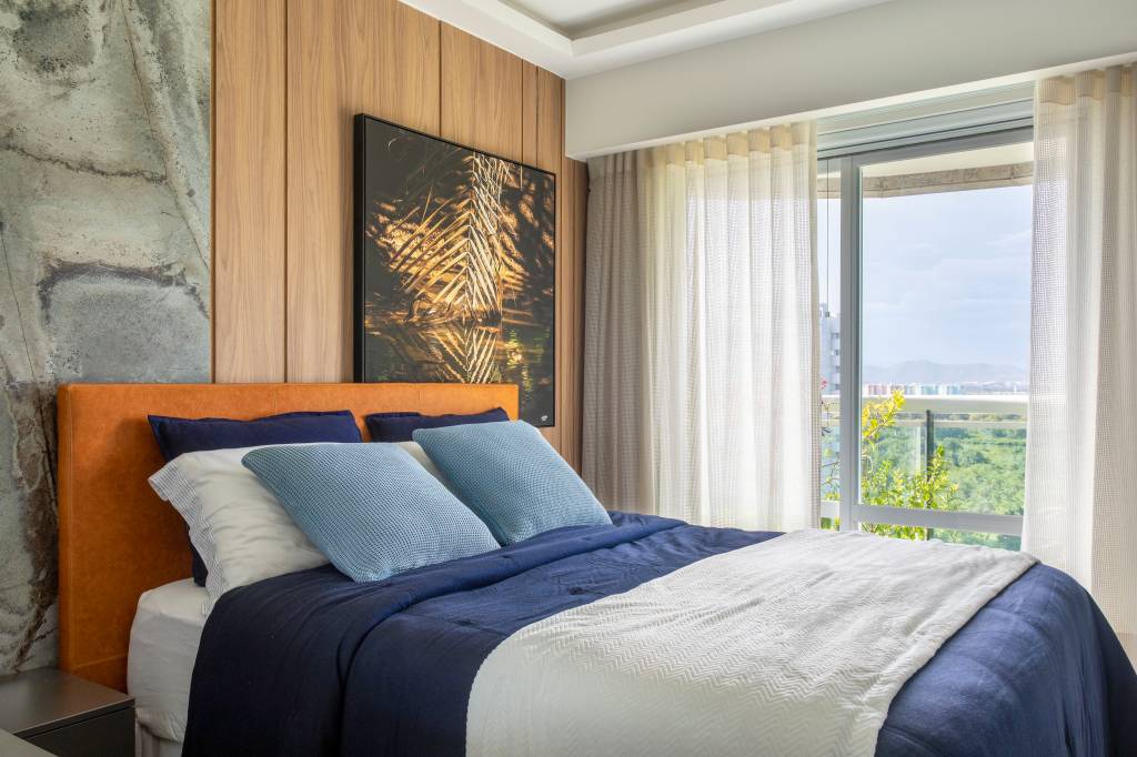 tons-terracota-automacao-marcam-ape-167m-virna-carvalho-11 Quarto com cama de casal, cortina e parede revestida de madeira com quadro.