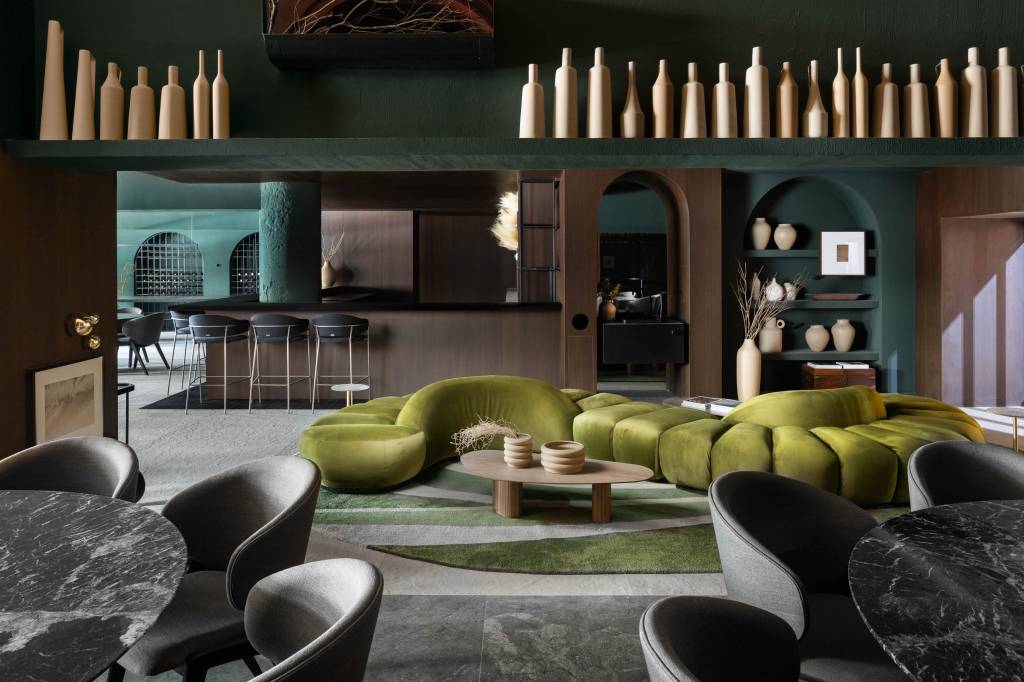 web_alteraarquitetura_casacor2023_mortattistudio-12 50 mil hastes de aspargos secos adornam o teto deste restaurante. Projeto de Renan Altera para a CASACOR SP 2023. Na foto, área de espera com sofá curvo verde, bar e e cerâmicas.
