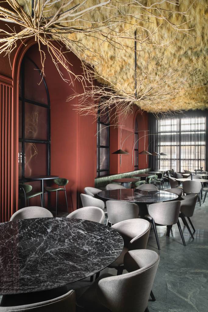 web_casacorsp_2023_alteraarquitetura_andremortatti-8 50 mil hastes de aspargos secos adornam o teto deste restaurante. Projeto de Renan Altera para a CASACOR SP 2023. Na foto, teto de aspargo, mesa preta e sofá verde.