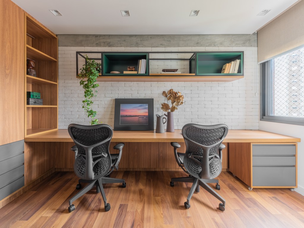 Projeto de Pietro Terlizzi. Na foto, home office duplo com bancada de madeira em quarto de hóspedes com sofá cama.