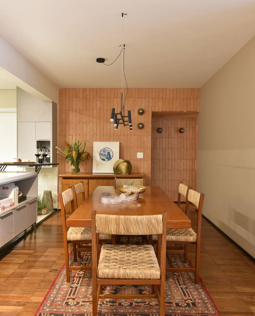 Sala de jantar com mesa de madeira e cadeiras com palha.