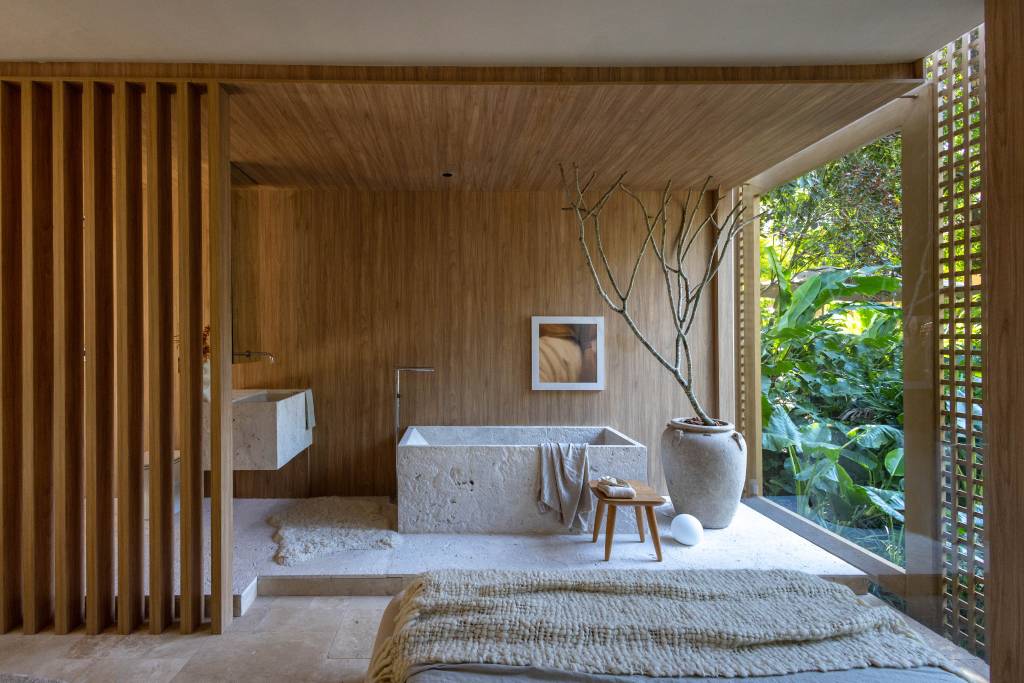 Fachada de muxarabi cria jogo de luz e sombra em quarto no meio de jardim