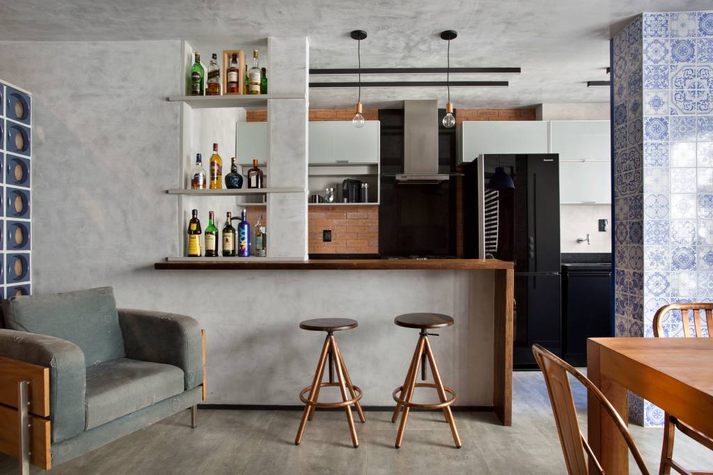 loft-70-m2-decor-industrial-inspirado-nova-york-rafael-mirza-credito-denilson-machado (2) Loft de 70 m² ganha décor industrial inspirado em Nova York. Projeto de Rafael Mirza. Na foto, sala de estar integrada com cozinha, mesa de refeições e parede de cimento queimado.