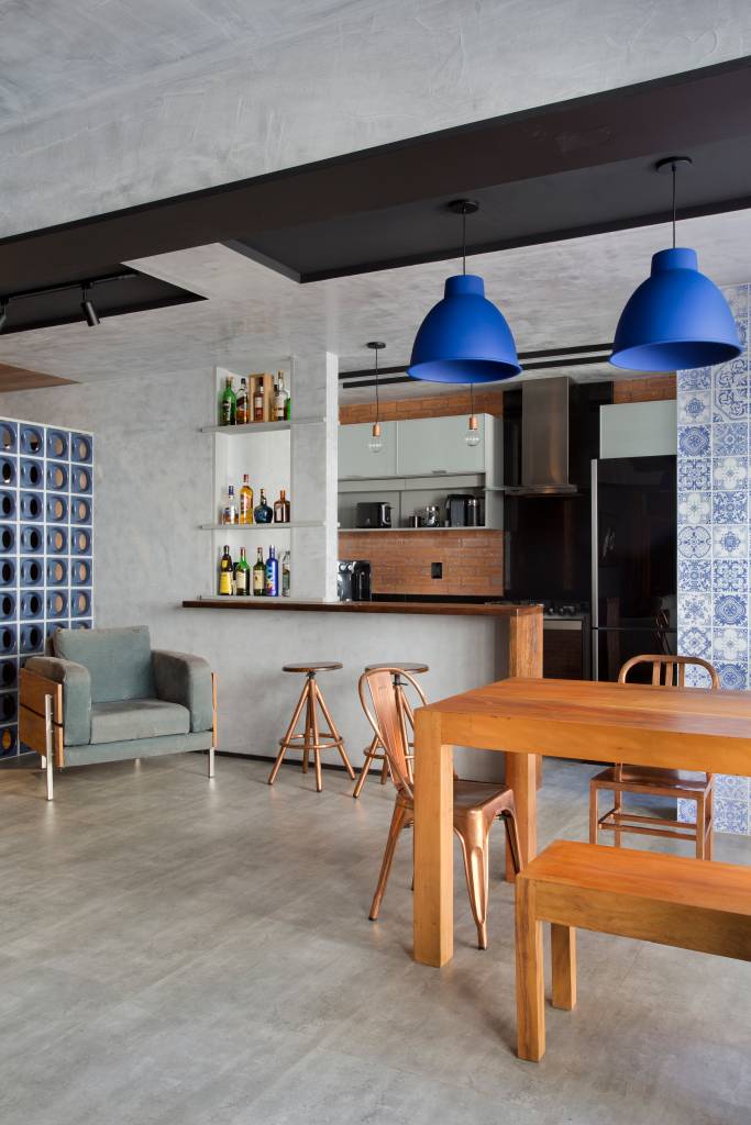 loft-70-m2-decor-industrial-inspirado-nova-york-rafael-mirza-credito-denilson-machado (3) Loft de 70 m² ganha décor industrial inspirado em Nova York. Projeto de Rafael Mirza. Na foto, sala de estar integrada com cozinha, mesa de refeições e parede de cimento queimado.