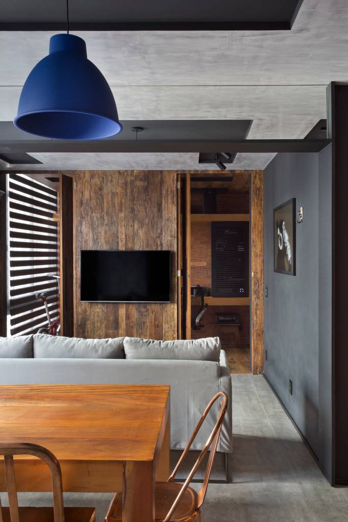 loft-70-m2-decor-industrial-inspirado-nova-york-rafael-mirza-credito-denilson-machado (6) Loft de 70 m² ganha décor industrial inspirado em Nova York. Projeto de Rafael Mirza. Na foto, sala com parede madeira e preta, mesa de madeira e detalhes pretos.