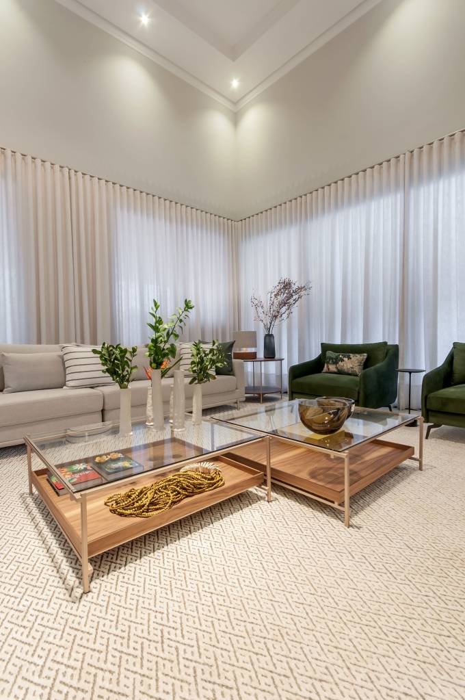mesa-de-centro-tipos-em-alta-e-dicas-paiva-e-passarini-arquitetura-05 Sala de estar com tapete branco e mesa de centro com tampo de vidro e estrutura metálica.