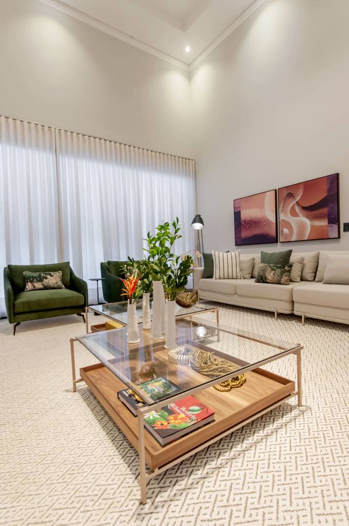 mesa-de-centro-tipos-em-alta-e-dicas-paiva-e-passarini-arquitetura-06 Sala de estar com tapete branco e mesa de centro com tampo de vidro e estrutura metálica.