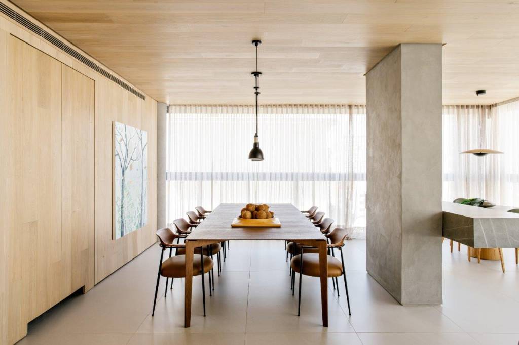 paineis-madeira-revestem-teto-escondem-portas-ape-220-m2-tres-arquitetura-credito-fran-parente (7) Painéis de madeira revestem o teto e escondem portas neste apê de 220 m². Projeto Très Arquitetura. Na foto, sala de jantar com parede de madeira e quadro.