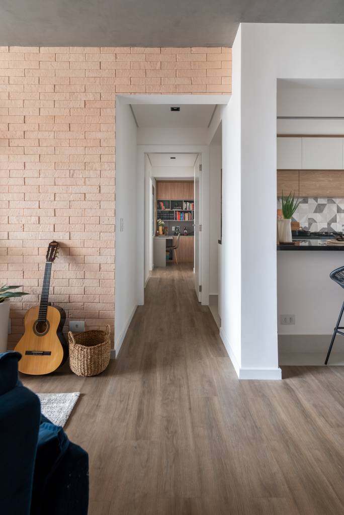 quarto-servico-vira-home-office-integrado-ao-quarto-ape-isabella-nalon-09-corredor-tijolinhos Projeto de Isabella Nalon. Na foto, corredor com piso vinílico e parede revestida de tijolinhos.