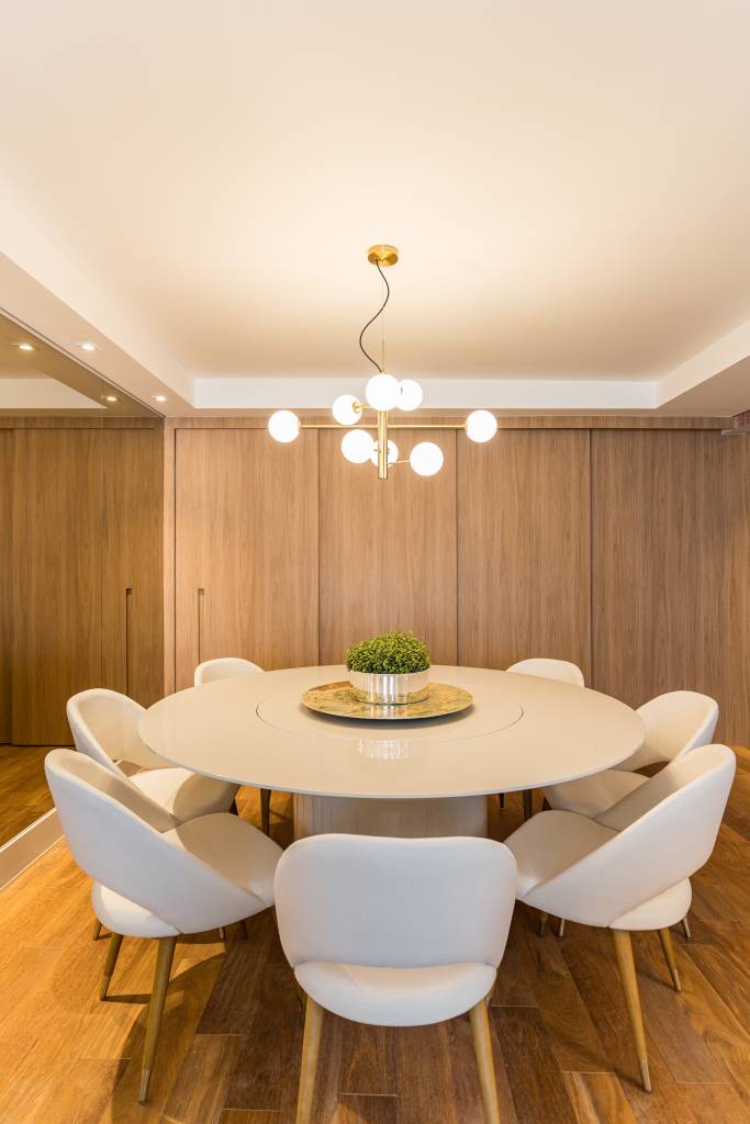 reforma-cria-suite-closet-integrado-spaco-interior-27 Sala de jantar com mesa redonda e cadeiras brancas. Cozinha com porta de correr ao fundo.