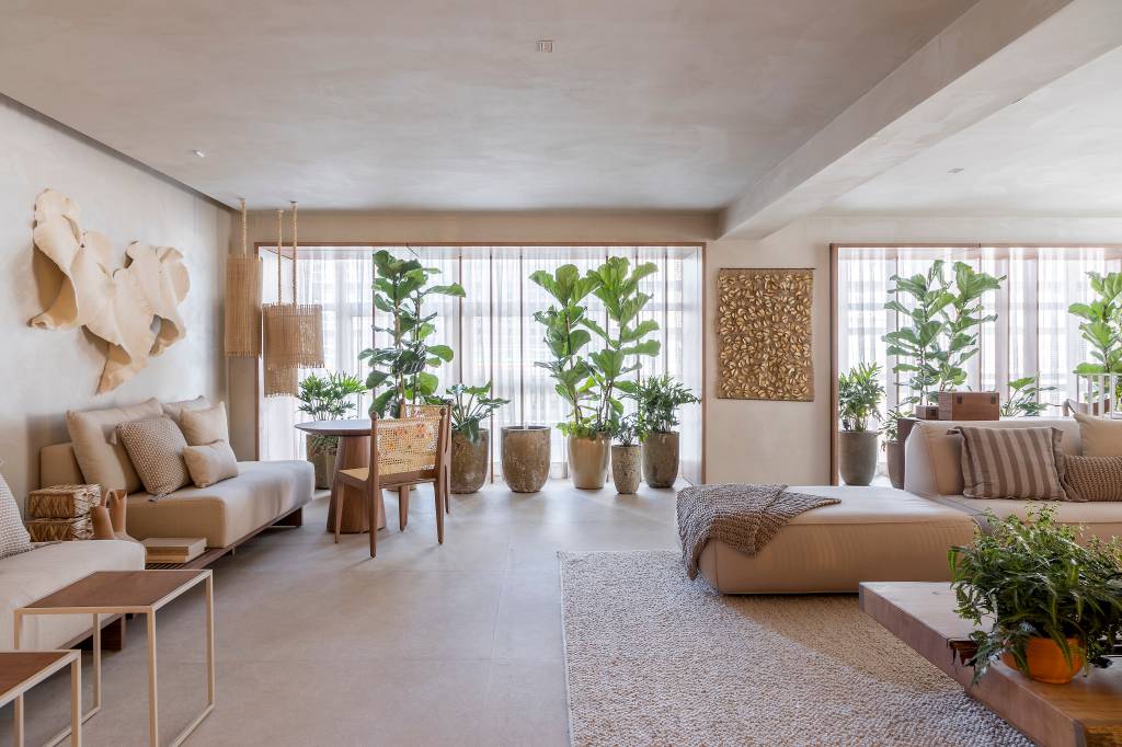 slow-living-sala-estar-refugio-materiais-naturais-artesanato-isabela-nallon-casacor-sp-2023-20 Sala de estar com tons beges claros, sofás beges, vasos com plantas grandes.