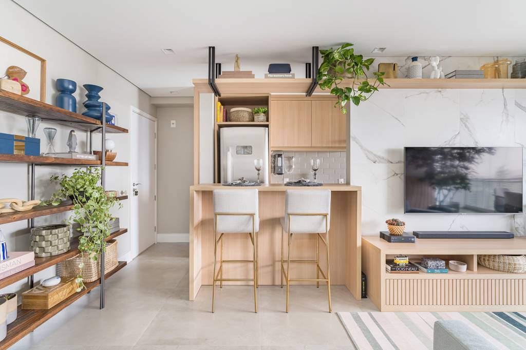 apartamento-60-m2-decor-delicado-repleto-madeira-plantas-bia-hajnal-credito-kadu-lopes (18) Apartamento de 60 m² ganha décor delicado repleto de madeira e plantas. Projeto de Bia Hajnal. Na foto, cozinha americana com balcão, prateleira suspensa e estante com lembranças de viagem.