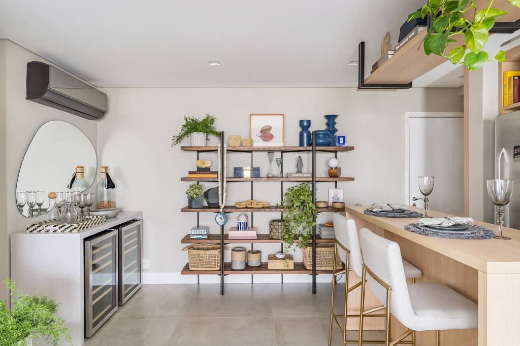 Apartamento de 60 m² ganha décor delicado repleto de madeira e plantas. Projeto de Bia Hajnal. Na foto, estante com lembranças de viagens e plantas.