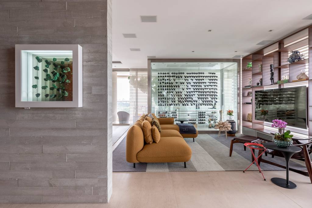ape-descolado-632-m2sofas-coloridos-adega-para-mil-garrafas-ana-weege-credito-rafael-renzo-(17) Apê descolado de 632 m² tem sofás coloridos e adega para mil garrafas. Projeto de Ana Weege. Na foto, sala de TV com adega e estante vazada.