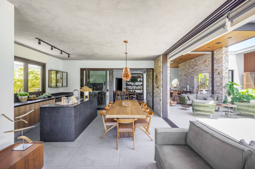 decor-contemporaneo-toques-rusticos-casa-campo-406m-tm-arquitetura-03 Projeto de TM Arquitetura. Na foto, área gourmet com piso de porcelanato, ilha revestida de granito preto, mesa rústica de madeira.