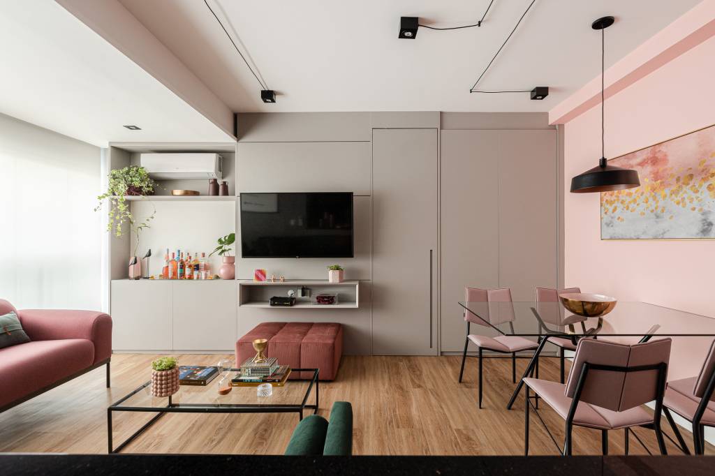 tons-rosa-verde-ape-inspirado-em-gossip-girl-inovando-arquitetura-21-sala Projeto de Inovando Arquitetura. Na foto, sala de estar integrada com trilhos de iluminação aparentes, parede rosa e parede cinza.