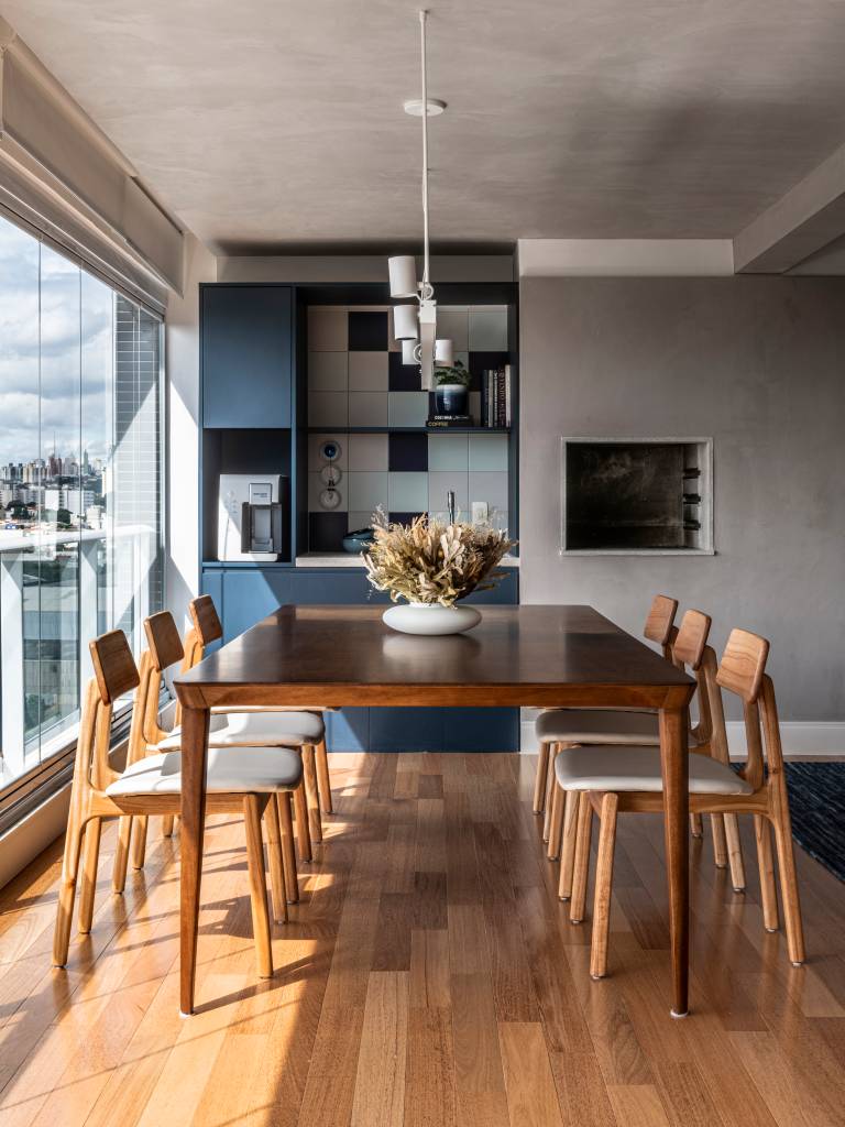 toques-azul-apartamento-integrado-130m-maoquadrado-07-area-gourmet Apartamento de 130m² com projeto de M² Arquitetura. Na foto, varanda gourmet com mesa de madeira e churrasqueira.