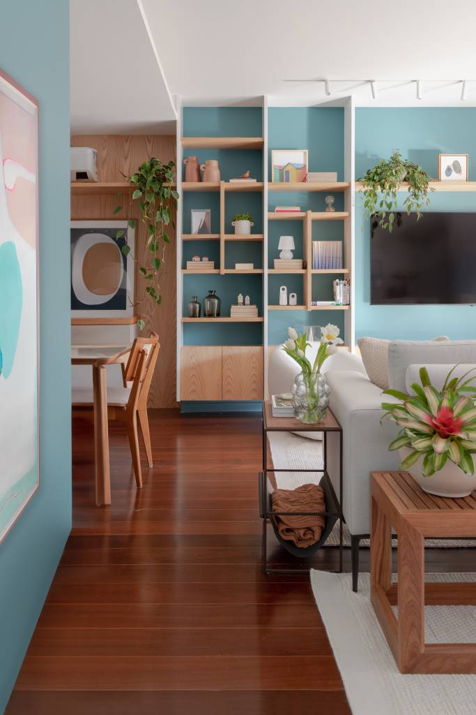 vibrante-atemporal-tons-verde-azul-ape-140m-maia-romeiro-arquitetura-10 Projeto de MR Arquitetura. Na foto, sala de estar integrada com jantar com parede azul e estante vazada com nichos.
