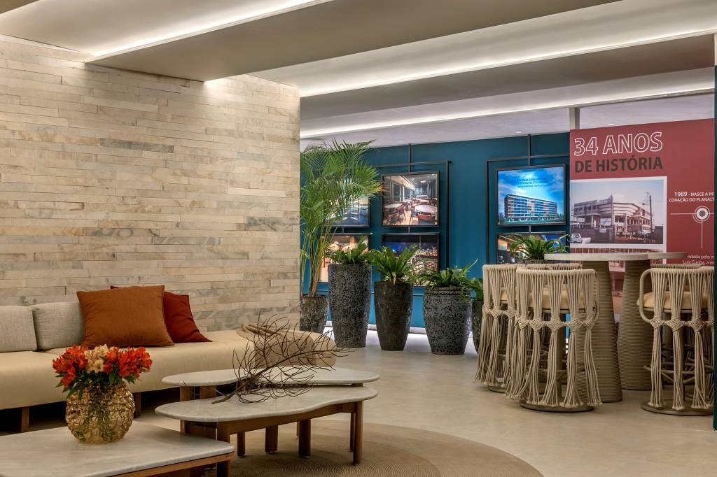 apartamento-189-m2-decor-afetivo-repleto-pecas-autorais-vivian-maia-casacor-brasilia-credito-edgard-cesar (1) Apartamento de 189 m² tem décor afetivo e repleto de peças autorais. Projeto de Vivian Maia para a CASACOR Brasília 2023. Na foto, sala com parede de pedra, azul e cadeiras de fibra.