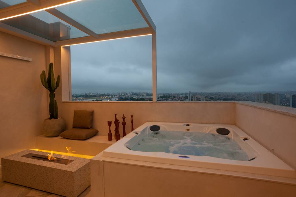 duplex-150-m2-area-externa-jacuzzi-escada-escultural-felipe-carolo-credito-ruca-reines (20) Dúplex de 150 m² ganha área externa com jacuzzi e escada escultural. Projeto de Felipe Carolo. Na foto, terraço com hidromassagem e lareira.