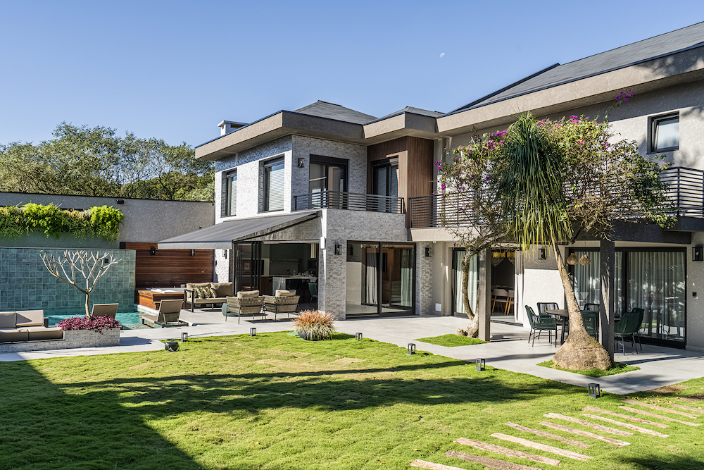 Reforma transforma casa da década de 1970 em uma moradia moderna de 600 m². Projeto de Soraya Surdi. Na foto, fachada da casa, jardim, varanda e piscina.